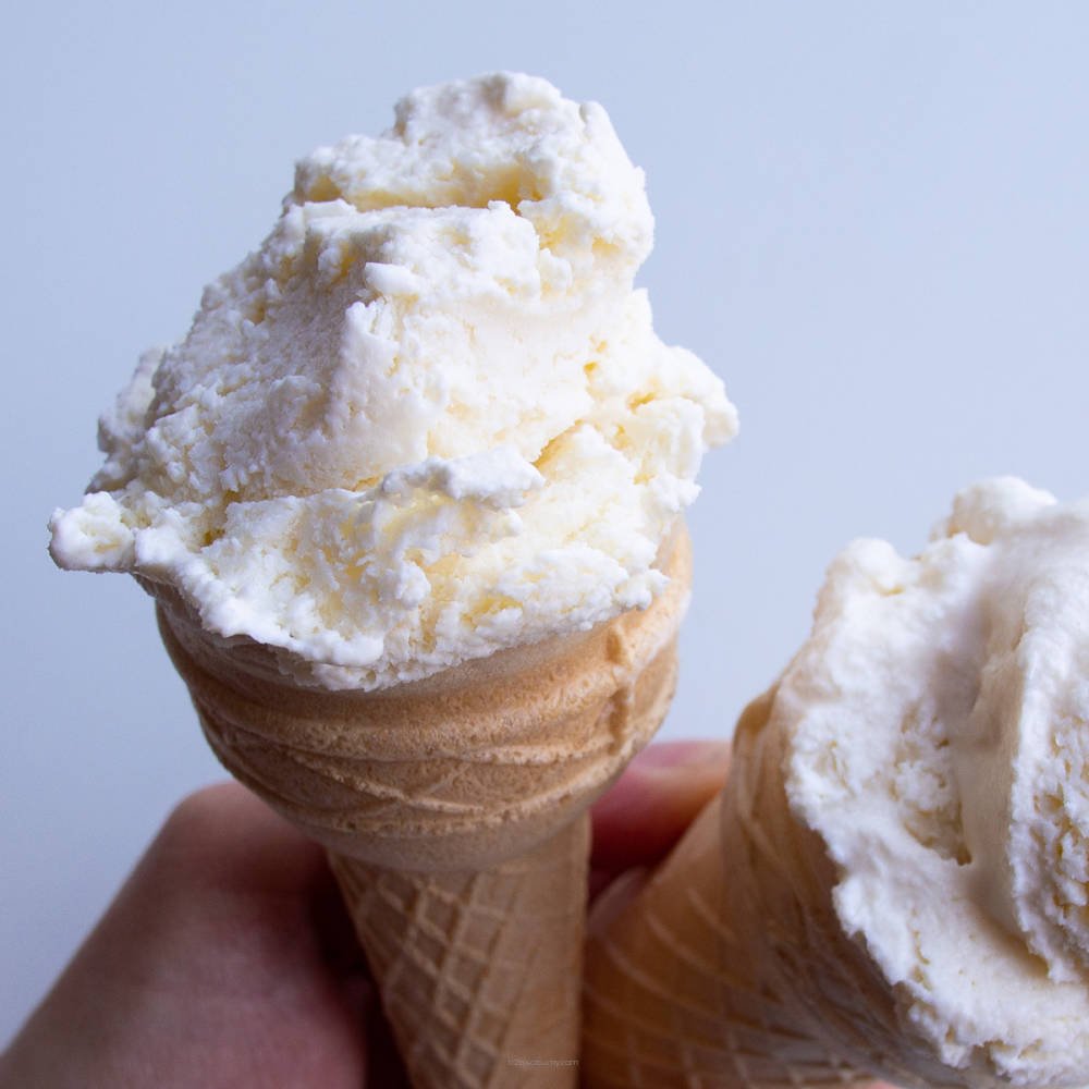 Creamy vanilla ice cream from Flavour World SA in a waffle cone with sprinkles, served on a sunny background.