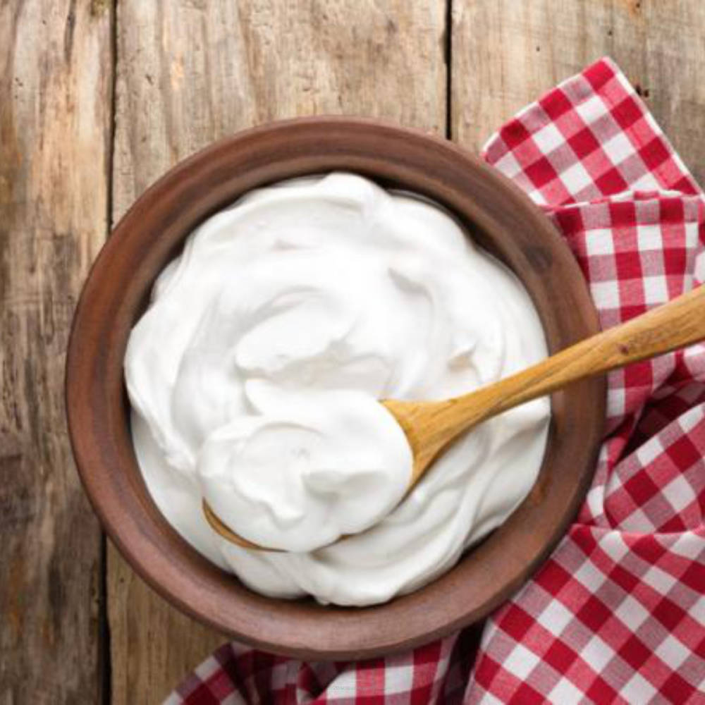 Cream topping in a jar labeled SSA Whipped Cream by Flavour World SA, showing the smooth, fluffy whipped cream inside.